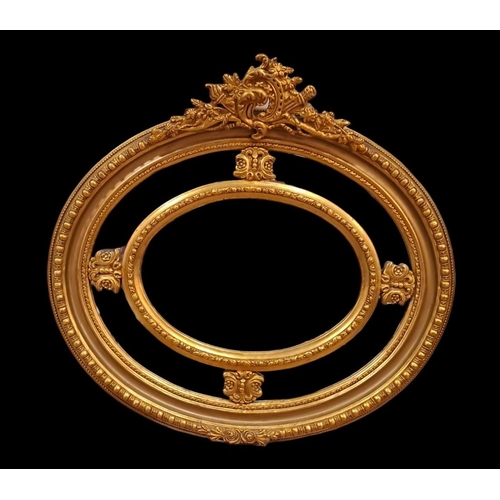 604 - A CONTINENTAL GILT FRAME COMPARTMENT MIRROR the oval bevelled glass plates joined by stylised flower... 