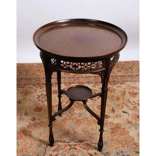 61 - A VINTAGE MAHOGANY OCCASIONAL TABLE the circular dished top above a pierced fretwork frieze raised o... 