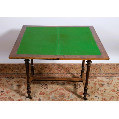 62 - A 19TH CENTURY WALNUT CROSSBANDED FOLDOVER CARD TABLE the shaped hinge top with baize lined interior... 