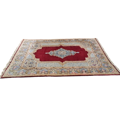 620 - A KESHAN WOOL RUG the wine, light blue and beige ground with central panel filled with floral panel ... 