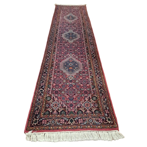 621 - A BIDJAR WOOL RUNNER the multicoloured ground with central serrated panel filled with stylised flowe... 