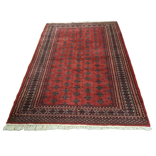 622 - A BOKHARA WOOL RUG the wine ground with central panel filled with stylised foliage within a rectangu... 