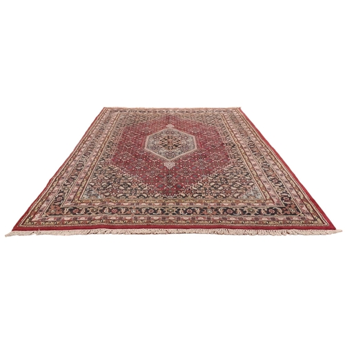 624 - A BIDJAR WOOL RUG the wine, indigo and beige ground with central panel filled with stylised flowerhe... 