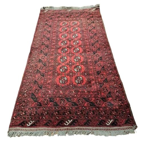 627 - A BOKHARA WOOL RUG the wine ground with central panel filled with paterae within a foliate and flowe... 