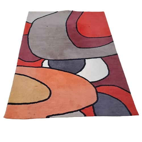 888 - A WOOL RUG the multicoloured ground with irregular panels 
200cm (l) x 140cm (w) 
A BEIGE AND FAWN S... 