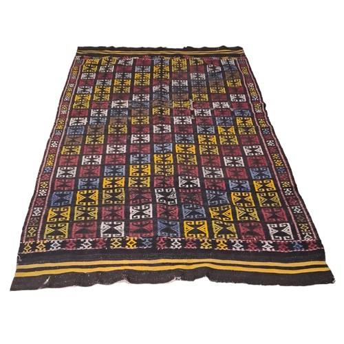 800 - A WOOL RUG the black ground with multicoloured panels with scroll decoration 
225cm (l) x 145cm (w),... 