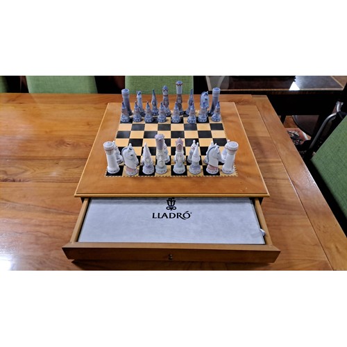 203 - A LLADRO PORCELAIN MEDIEVAL CHESS SET on an inlaid chess board of square form with frieze drawer and... 