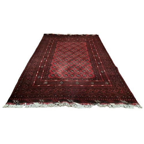 626 - A SHIRAZ WOOL RUG the wine ground with central panel filled with stylised flowerheads, palmets and h... 