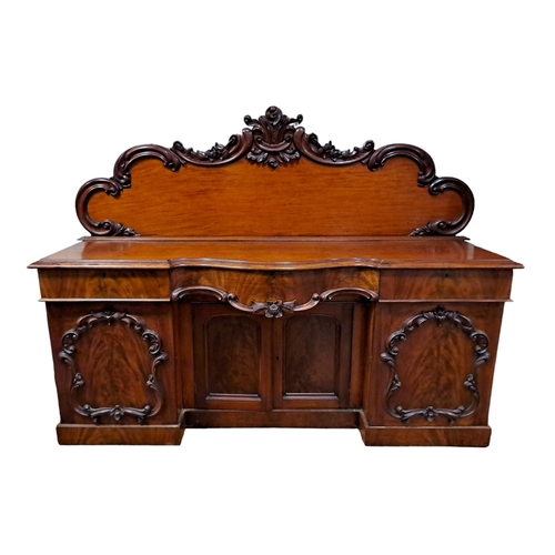 54 - A VICTORIAN MAHOGANY SIDEBOARD of serpentine outline the shaped top with carved and moulded back abo... 