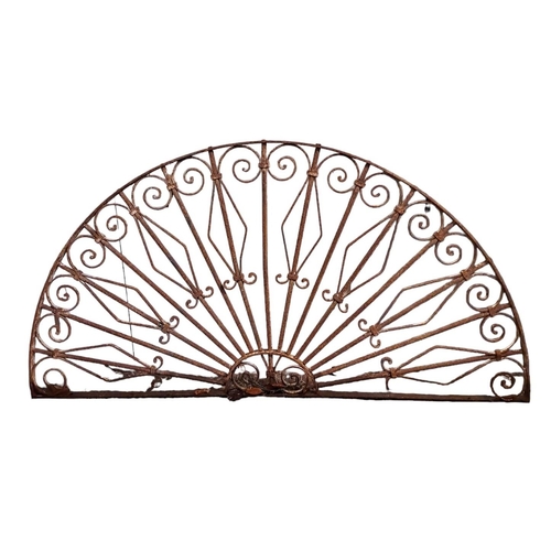 696 - A WROUGHT IRON FAN LIGHT of demi lune outline with scroll and cylindrical barring 
88cm (h) x 163cm ... 