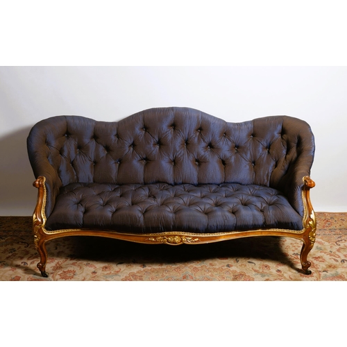 12 - A 19TH CENTURY WALNUT PARCEL GILT AND UPHOLSTERED SETTEE the serpentine shaped back with deep button... 