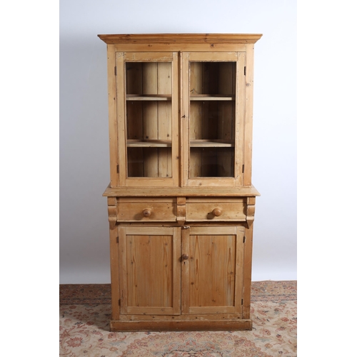 213 - A VINTAGE PINE DRESSER the moulded cornice above a pair of glazed doors containing shelves the base ... 