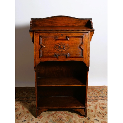 24 - A VINTAGE OAK BUREAU BOOKCASE the rectangular top with moulded three quarter gallery above a hinged ... 