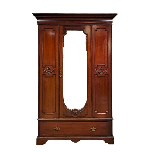 28 - AN EDWARDIAN CARVED MAHOGANY WARDROBE the moulded cornice above a bevelled glass mirrored door conta... 