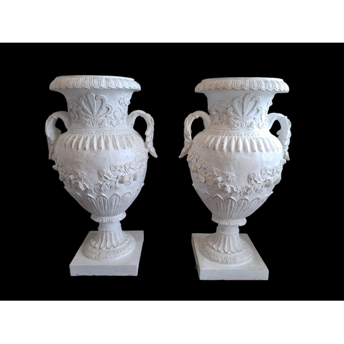 599 - A PAIR OF COMPOSITION URNS each of semi lobed campana form the foliate scroll handles above an ovoid... 