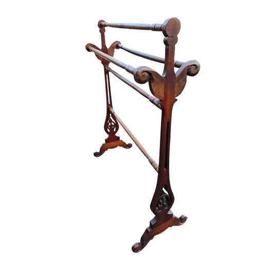 716 - A MAHOGANY FIVE BAR TOWEL RAIL the pierced scroll end standards joined by baluster rails with scroll... 