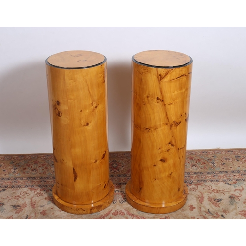 49 - A PAIR OF ART DECO STYLE WALNUT PEDESTALS each of cylindrical form raised on a circular platform 
80... 