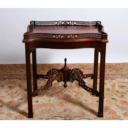 72 - A CHIPPENDALE STYLE MAHOGANY TRAY ON STAND of serpentine outline the shaped top with pierced fretwor... 