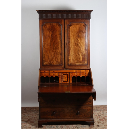 181 - A GEORGIAN MAHOGANY BUREAU BOOKCASE the dentil and stop fluted frieze above a pair of crossbanded pa... 