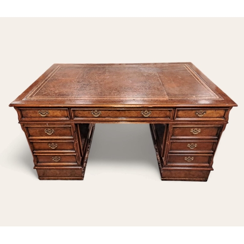 367 - A GEORGIAN STYLE WALNUT PEDESTAL DESK of rectangular outline the shaped top with tooled leather inse... 