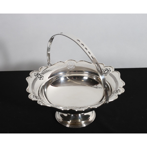 500 - A SILVER SWING HANDLE BASKET with pierced rim raised on a circular spreading foot 
Chester 1929
17 t... 