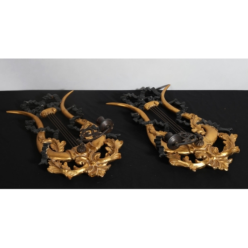 152 - **WITHDRAWN** A PAIR OF CONTINENTAL GILTWOOD AND EBONISED WALL SCONCES the lyre shaped back plate wi... 