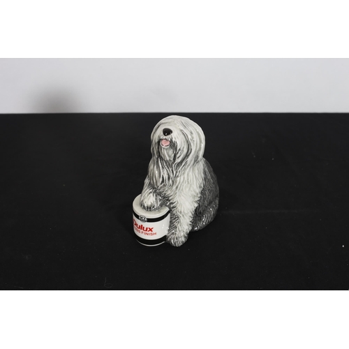 314 - A ROYAL DOULTON FIGURE modelled as Dulux Dog shown standing with one paw resting on a tin of paint i... 