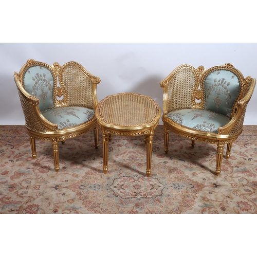 336 - A CONTINENTAL THREE PIECE GILTWOOD CANED AND UPHOLSTERED SUITE comprising a pair of salon armchairs ... 