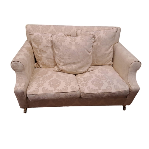 495 - A TWO SEATER SETTEE the rectangular upholstered back and seat with loose cushions and scroll over ar... 