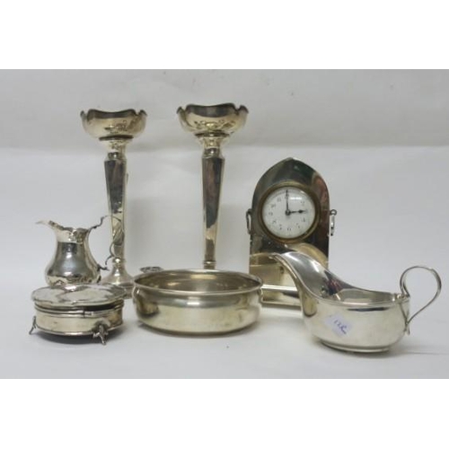 511 - A COLLECTION OF SILVER to include a pair of vases, a sauceboat, a silver case clock, a cream jug, et... 