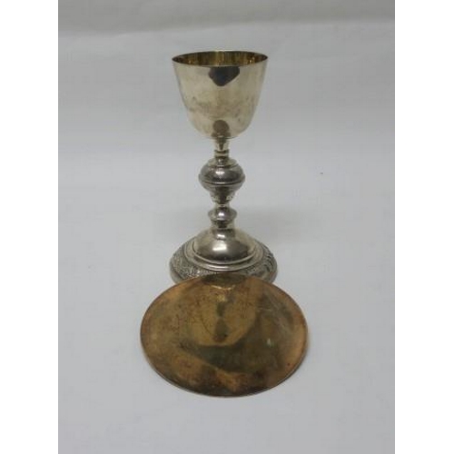 523 - A SILVER AND GILT LINED CHALICE embossed with fruiting vines inscribed 'I.H.S.' together with silver... 