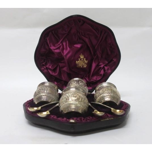 551 - FOUR SILVER EMBOSSED AND GILT LINED SALTS AND SPOONS in case London 1885 (8)