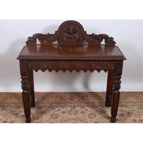 658 - A 19TH CENTURY CARVED MAHOGANY SIDE TABLE of rectangular outline the carved back centred by a figura... 