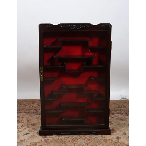 665 - A CHINESE HARDWOOD WALL MOUNTED DISPLAY CABINET of rectangular outline with glazed door and stepped ... 