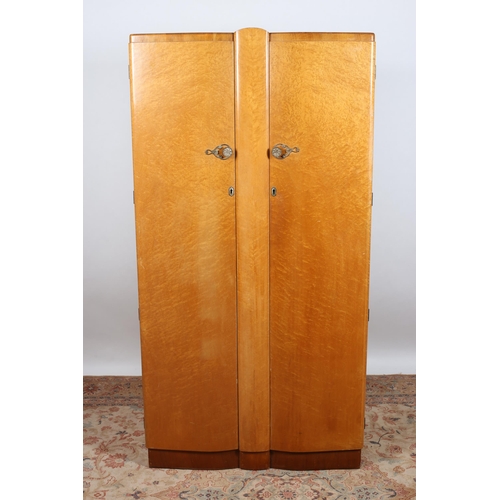 720 - A VINTAGE WALNUT TWO DOOR WARDROBE of rectangular bowed outline containing hanging rail, shelves and... 