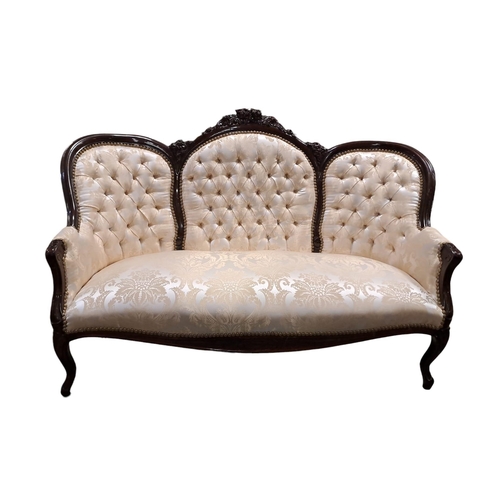 90 - A VICTORIAN DESIGN CARVED MAHOGANY AND UPHOLSTERED TRIPLE CHAIR BACK SETTEE with foliate and flowerh... 