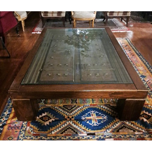 368 - AN EASTERN OAK AND GLAZED COFFEE TABLE of rectangular outline the shaped top with glazed panel conta... 