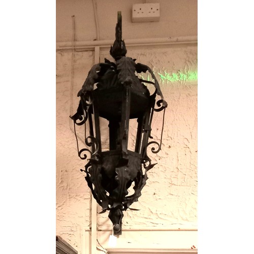 122 - A PAIR OF WROUGHT IRON WALL MOUNTED LANTERNS each of octagonal form with foliate decoration raised o... 