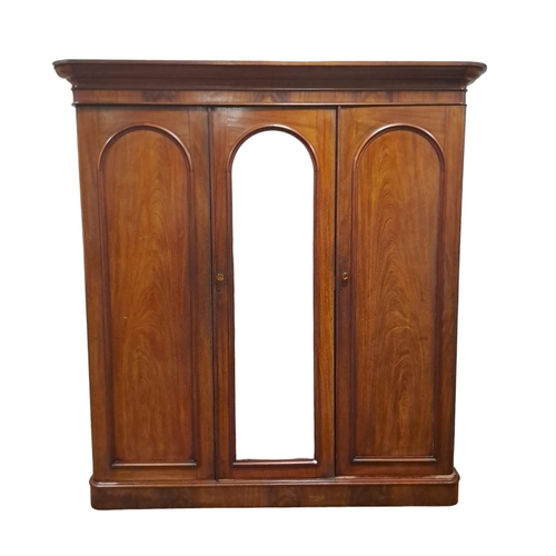 75 - A 19TH CENTURY MAHOGANY WARDROBE the moulded cornice above a central rectangular arched mirrored doo... 