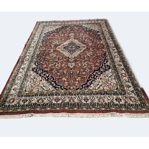 522 - A TABRIZ WOOL RUG the maroon, beige and indigo ground with central panel filled with stylised flower... 