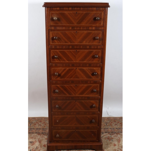 25 - A CONTINENTAL MAHOGANY AND SATINWOOD INLAID TALLBOY of rectangular outline the shaped top above eigh... 