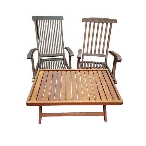 428 - TWO TEAK AND BRASS MOUNTED FOLDING PATIO ELBOW CHAIRS each with a slatted back and seat together wit... 