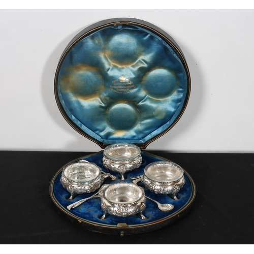 482 - A SET OF FOUR SILVER EMBOSSED SALTS on pad feet with FOUR SILVER SALT SPOONS London 1892 in original... 