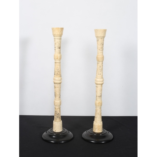 488 - A PAIR OF JAPANESE CARVED BONE CANDLESTICKS raised on a hardwood stand 
41cm (h)