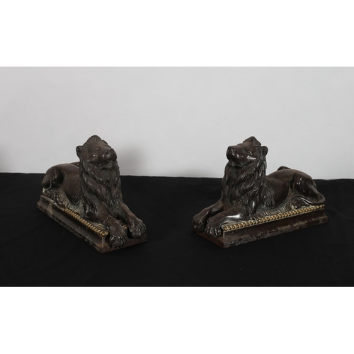 510 - A PAIR OF 19TH CENTURY CAST IRON AND BRASS FIGURES each modelled as a lion shown recumbent 
17cm (h)... 