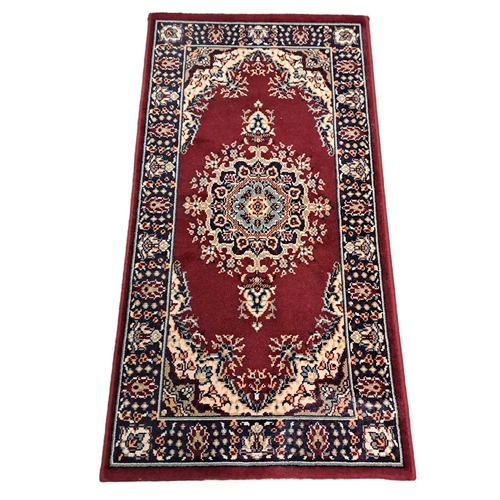 530 - A SET OF THREE SALL WOOL RUGS the wine ground with central panel filled with stylised flowerheads wi... 