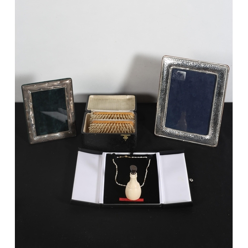 539 - TWO SILVER PHOTO FRAMES, a mother of pearl card case, a pair of silver engine turned brushes in case... 