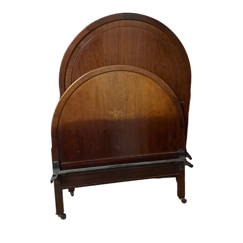 565 - TWIN MAHOGANY VINTAGE BEDS of rectangular arched outline on square moulded legs with castors 
131cm ... 