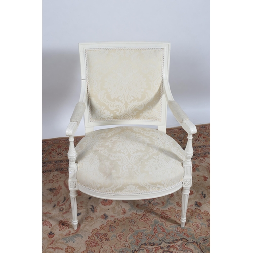 82 - A CONTINENTAL WHITE PAINTED AND UPHOLSTERED ELBOW CHAIR the rectangular upholstered panel back above... 