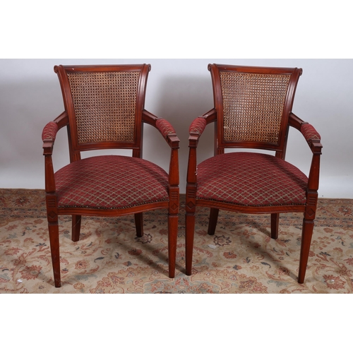 176 - A PAIR OF CONTINENTAL STAINED BEECHWOOD CANED AND UPHOLSTERED ARMCHAIRS each with a scroll over top ... 